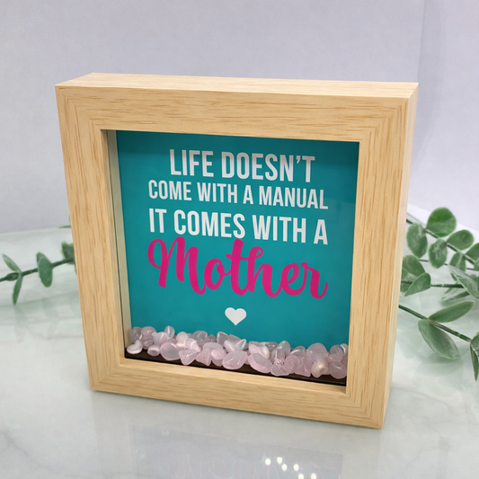 Wooden shadow box frame with Life Doesn’t Come With a Manual quote and rose quartz crystals